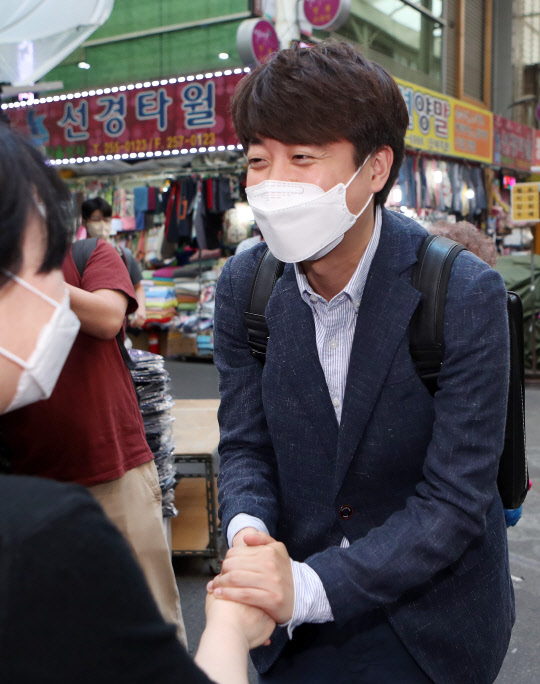 지난 5월24일 국민의힘 당대표 예비후보인 이준석 전 최고위원이 대구 중구 서문시장을 찾아 상인과 인사를 하고 있다.연합뉴스